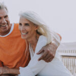 Retired couple embracing on the beach.