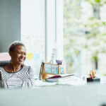 Older woman smiling and looking off into the distance.