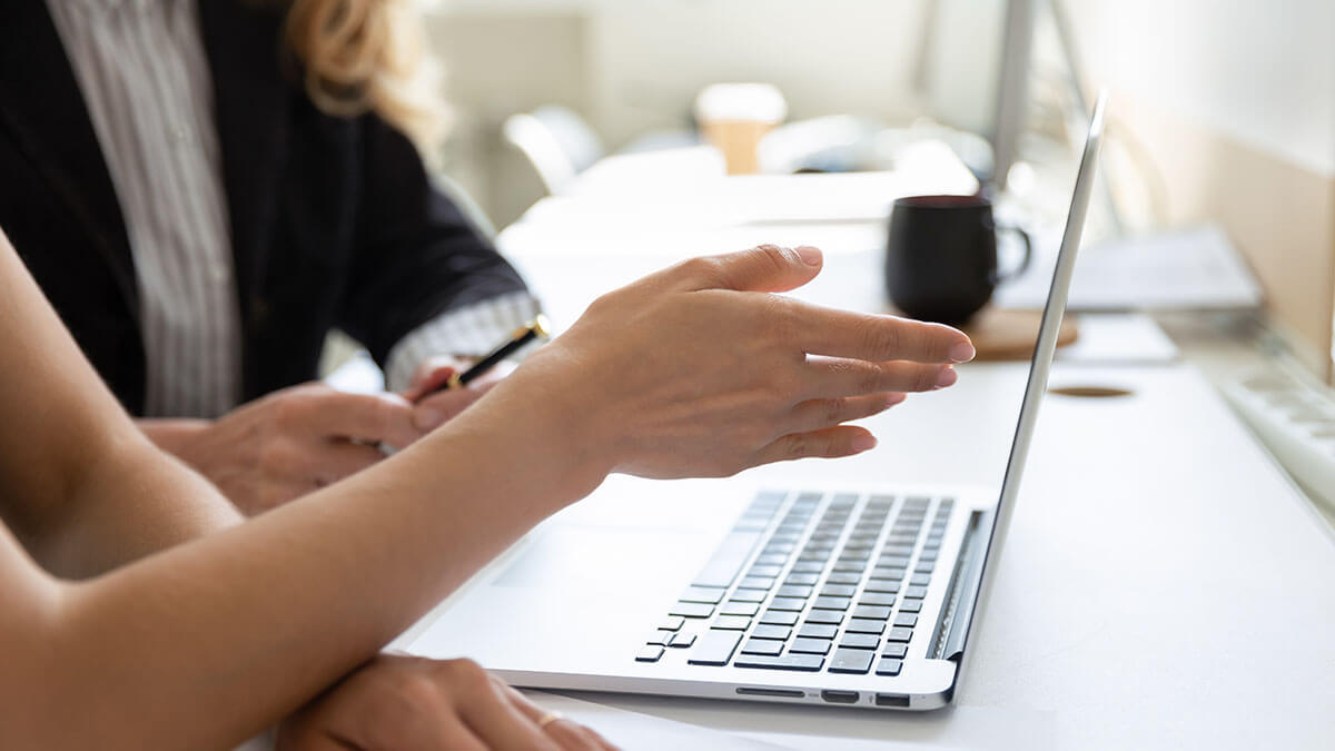 Employee gesturing at a laptop.