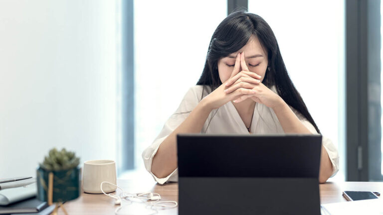 Stressed woman with hands over her nose.