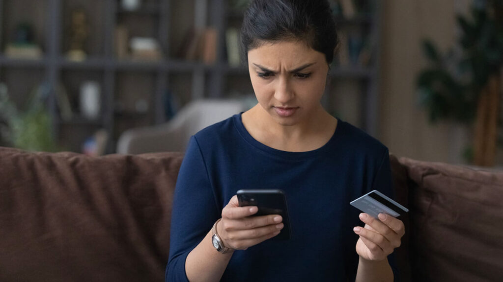 Woman confused by bank account fraud in her online account.