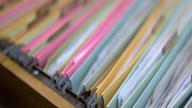 Different colored folders with payroll records inside.