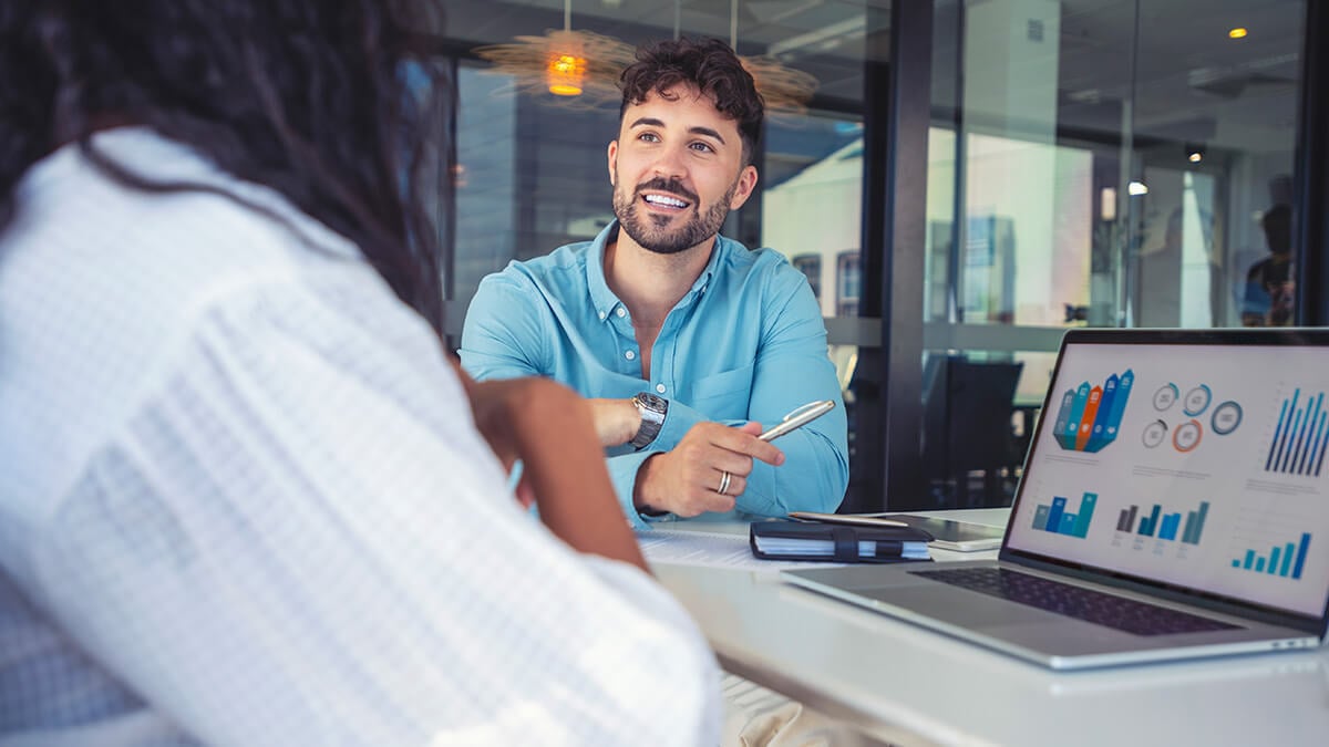 Man and woman discussing how to improve financial reporting processes.
