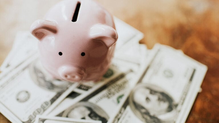 Piggy bank on a pile of money.