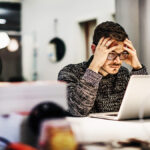 Stressed man with hands on his head.