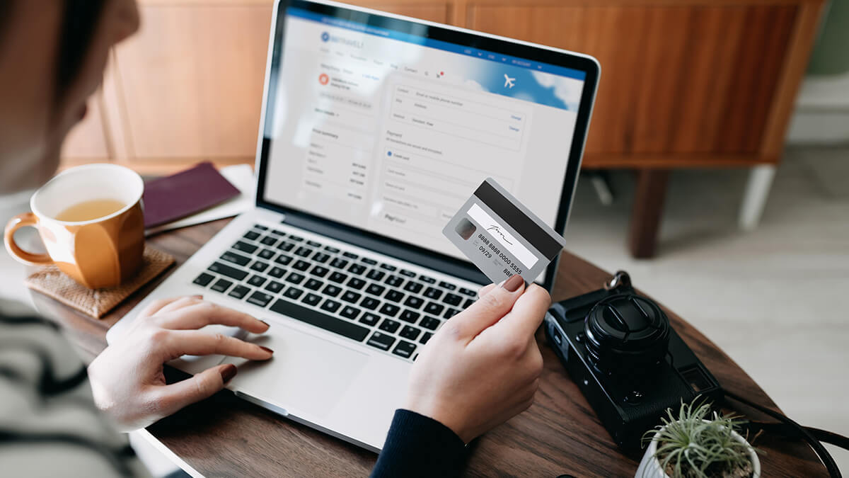 Woman entering credit card information into laptop.