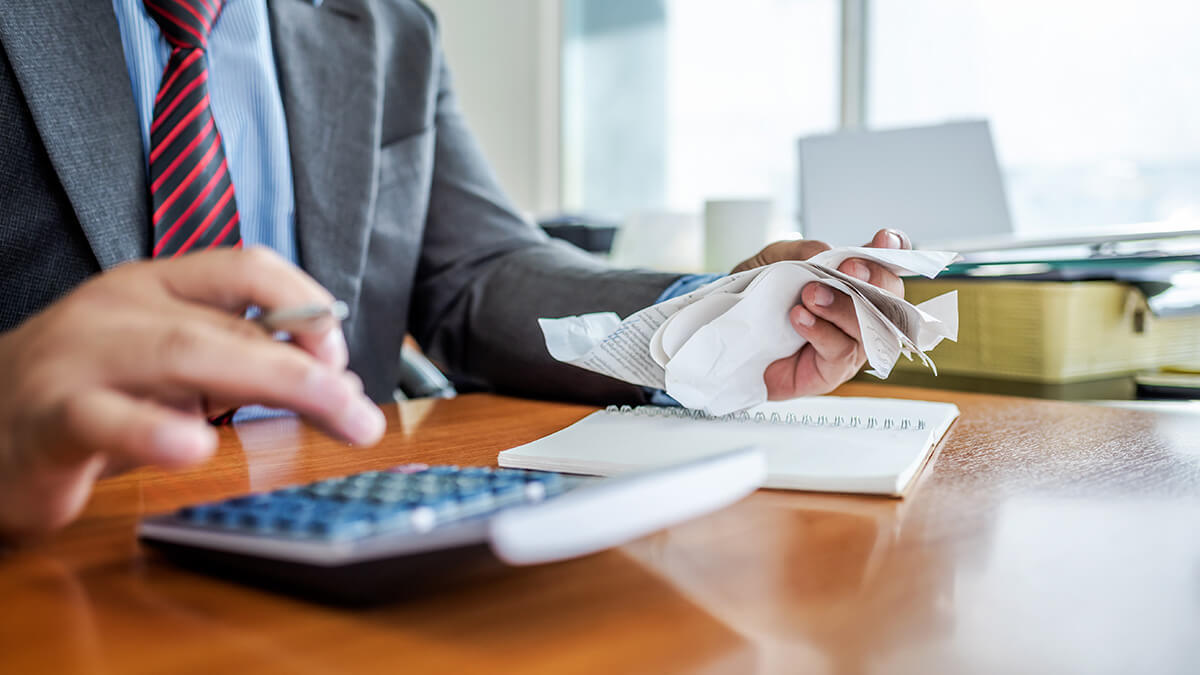 Man in a suite holding a handful of business receipts.