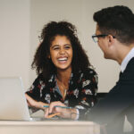 Woman smiling at male co-worker.