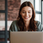 Smiling woman on laptop.