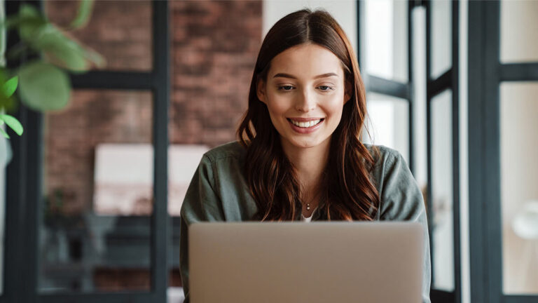 Smiling woman on laptop.