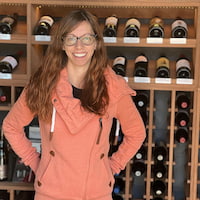 Patriot Software Basic payroll customer Kelsey Daniels in front of wine wall.