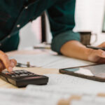 Business owner using a tablet and calculator.