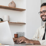 Man smiling at computer.