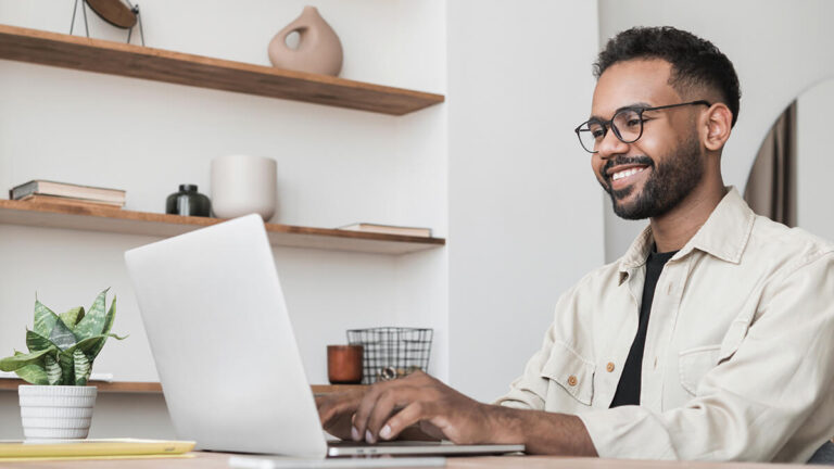 Man smiling at computer.