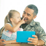Dad in military uniform with daughter.