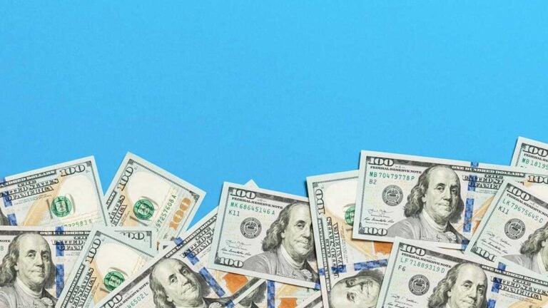 $100 bills on a blue background.