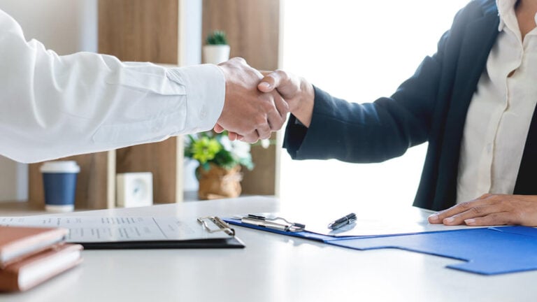Interviewer and candidate shaking hands.