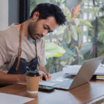 Man in an apron working at his desk.