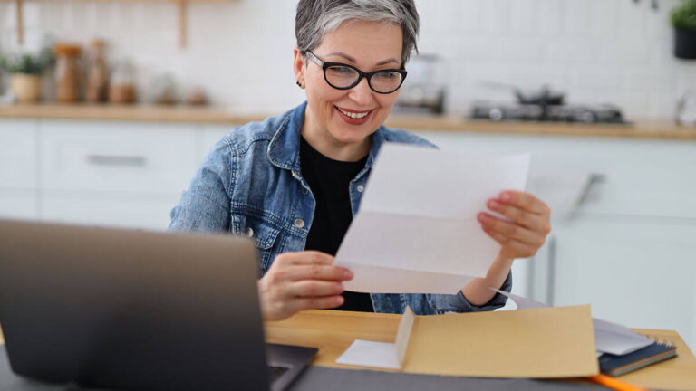 Woman smiling at a piece of paper with her company's assigned EIN.
