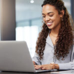 Woman smiling at the laptop.