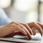 Hands typing on a keyboard.