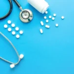 Stethoscope and pharmaceutical pills on a blue background