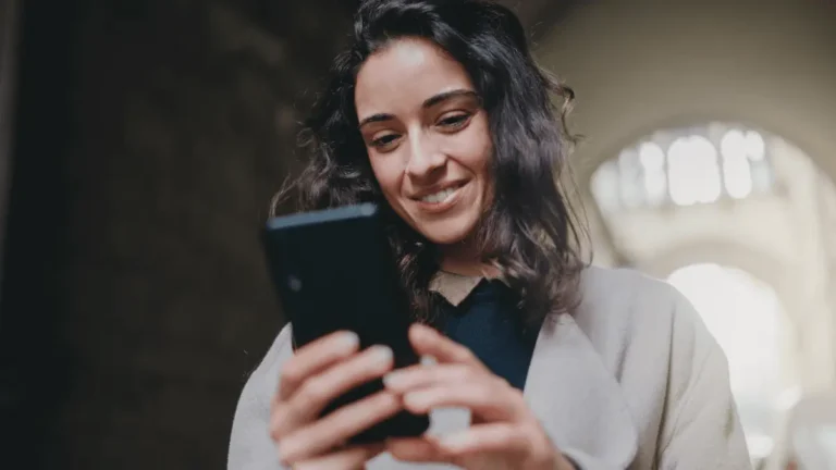 Woman looking at her phone to handle direct deposit.