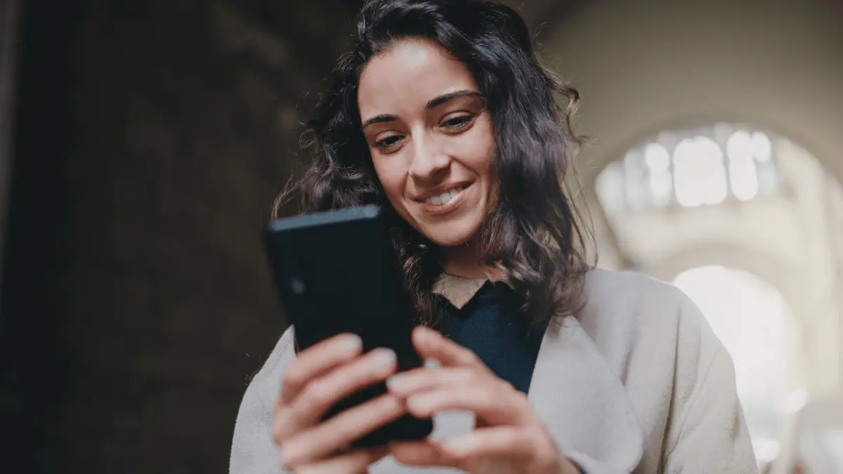 Woman looking at her phone to handle direct deposit.