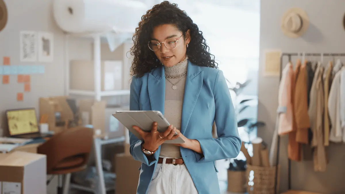 Business owner on her tablet learning how to choose a payroll service.