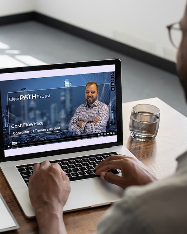 Accountant watching Cash Flow Mike's "The 7-Minute Conversation" webinar on desktop.