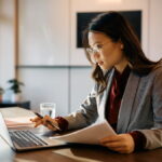 Woman reading through beneficial ownership information documents.