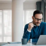 Employer on his laptop to generate pay stubs for employees
