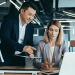 man and woman looking at machine learning in accounting on a laptop