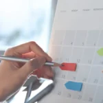 Employer marking their calendar for payroll cutoffs and pay dates.