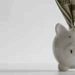 Piggy bank with money signifying payroll costs.