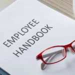 Employee handbook and red glasses