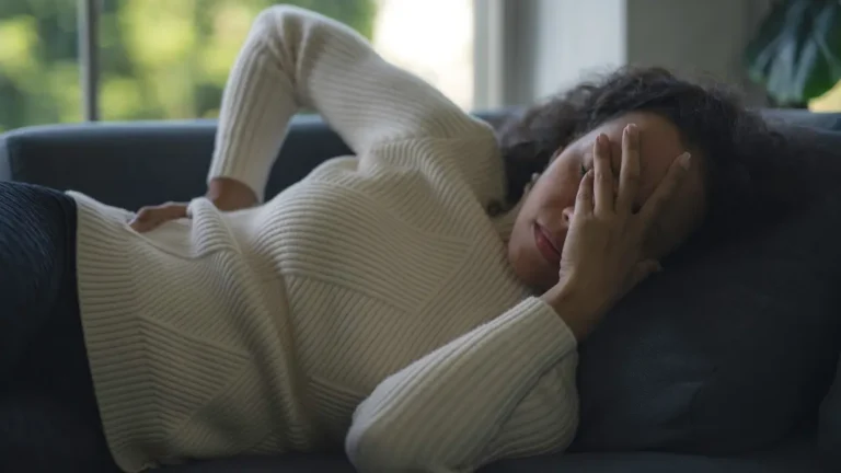 Woman with a migraine taking advantage of Alaska paid sick leave.
