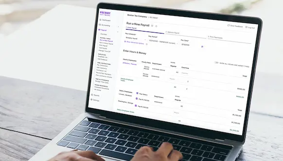 Person using laptop to run payroll.