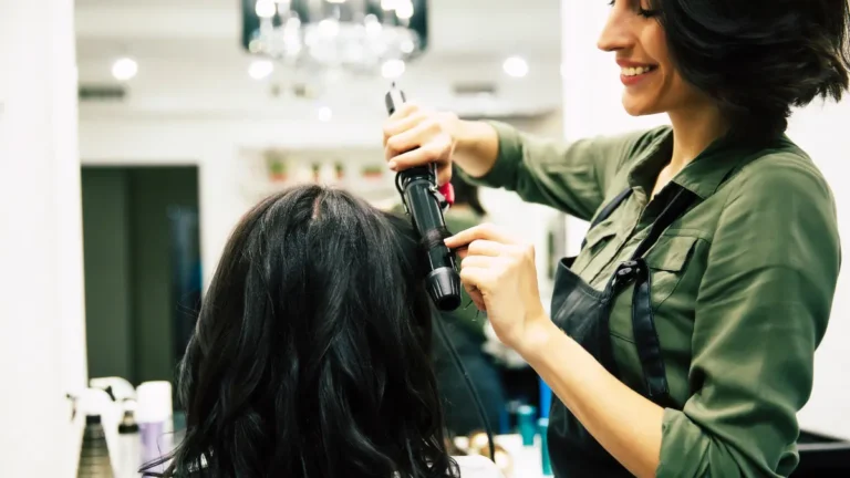 Tipped employees curling her client's hair.