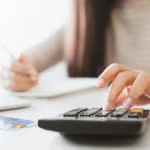 Business owner calculating payroll insurance costs.