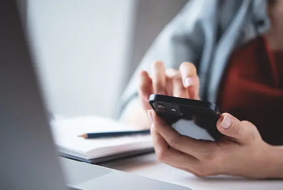 Woman using phone and laptop