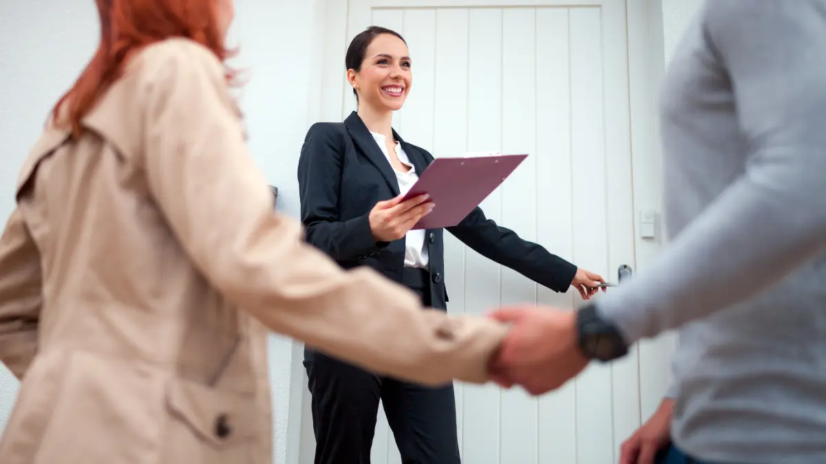 Real estate agent showing a home to a young couple.