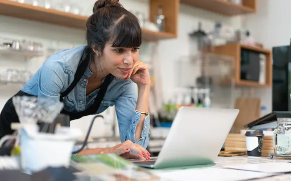 Happy business owner using laptop