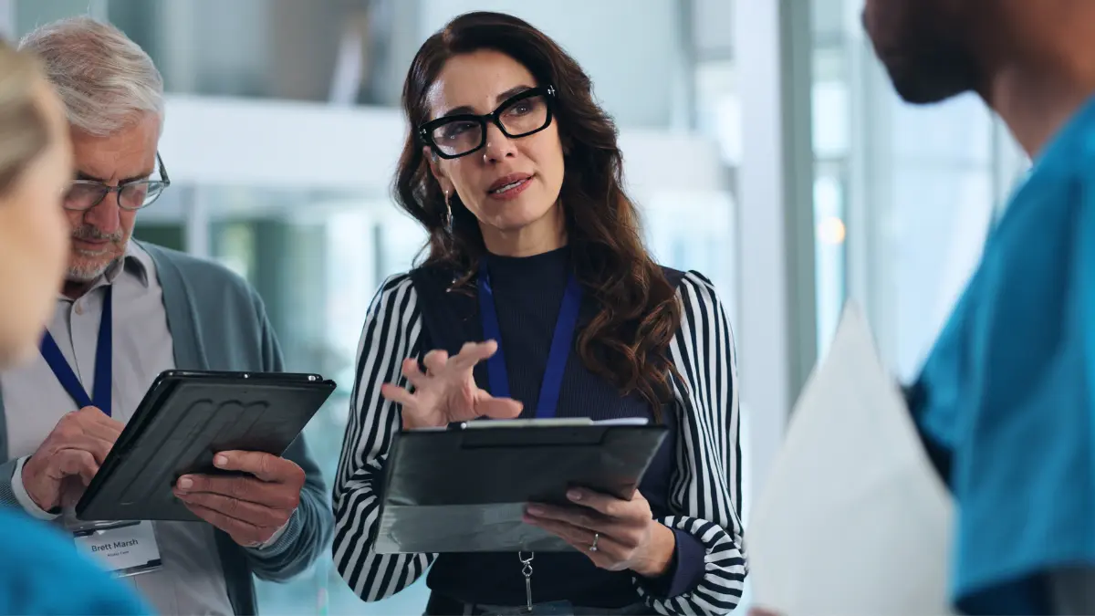 Payroll administrator speaking with staff about centralized payroll.