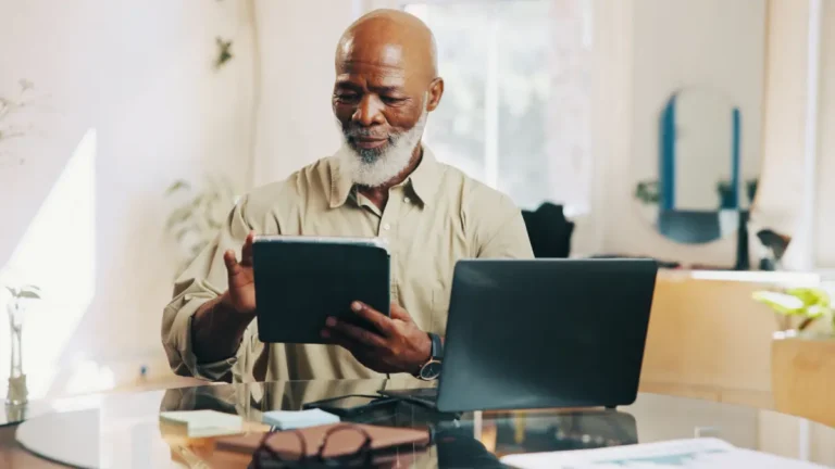 Man using tablet to learn how to catch up on past-due payroll taxes.